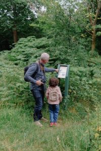 picture of adult man and small girl looking at a outdoor information sign