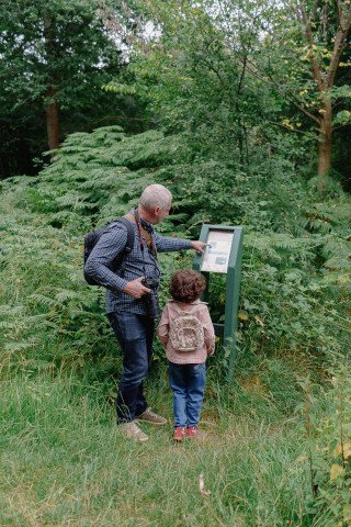 picture of adult man and small girl looking at a outdoor information sign
