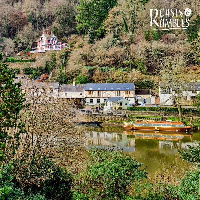 picture of white and timber framed buildings along roiver bank, taken from opposite side of river