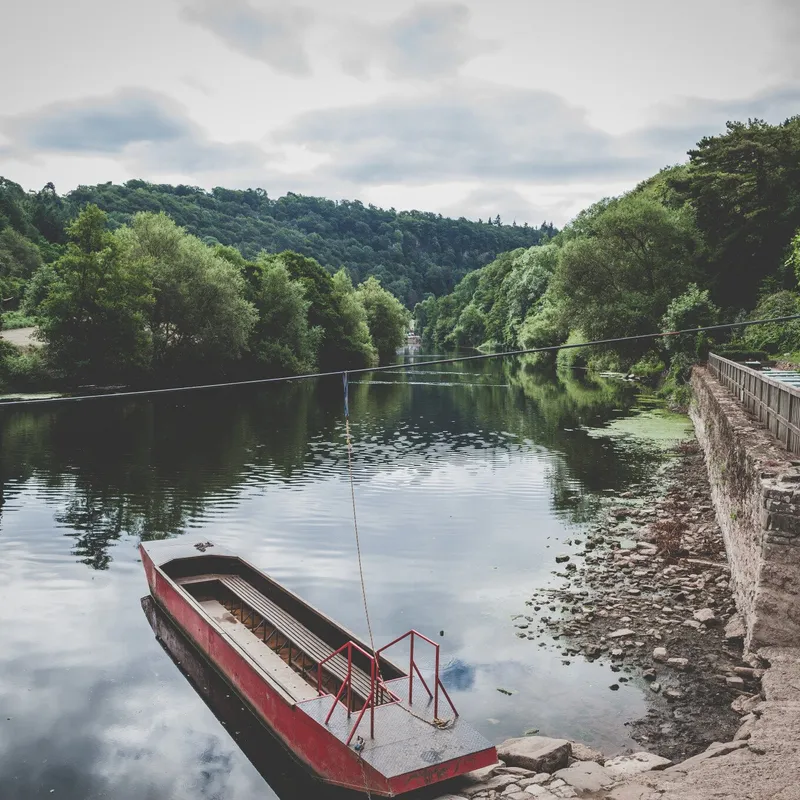 picture of riverbank with red hand pulled ferry docked
